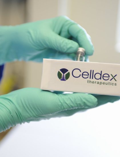 Closeup of scientist's hands placing vial in Celldex box