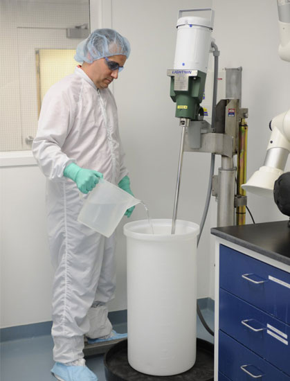 Celldex scientist pouring liquid in lab