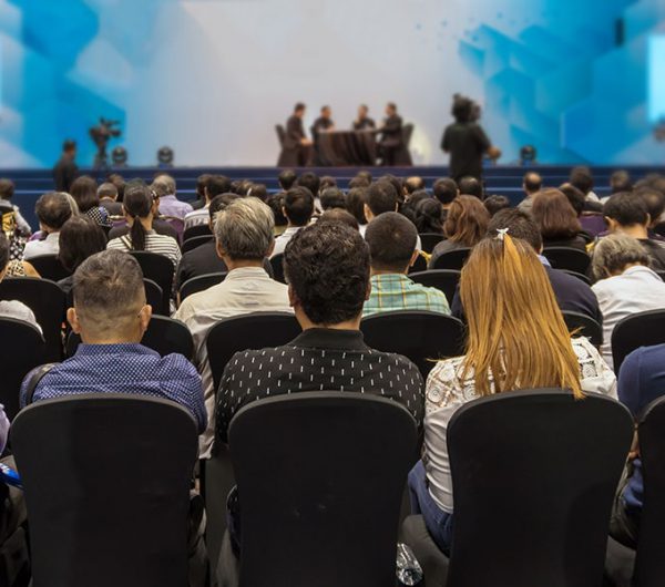 Image of people watching a presentation at a conference